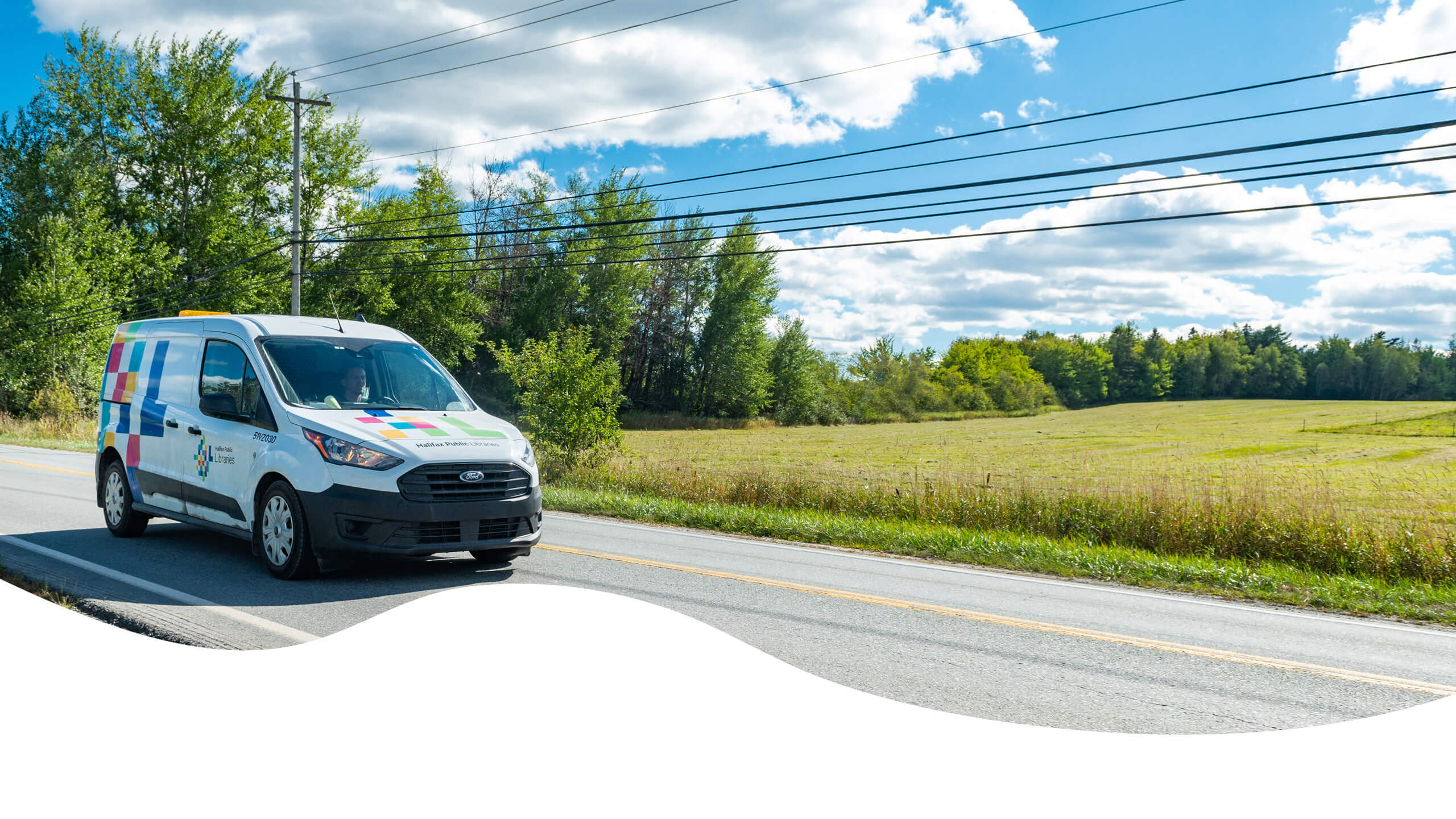 Halifax Public Libraries branded van driving on road.